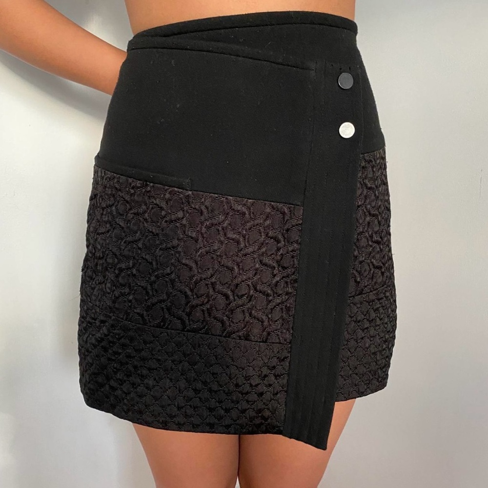 CAbi black quilted wrap mini skirt with an asymmetrical hem and snap closure